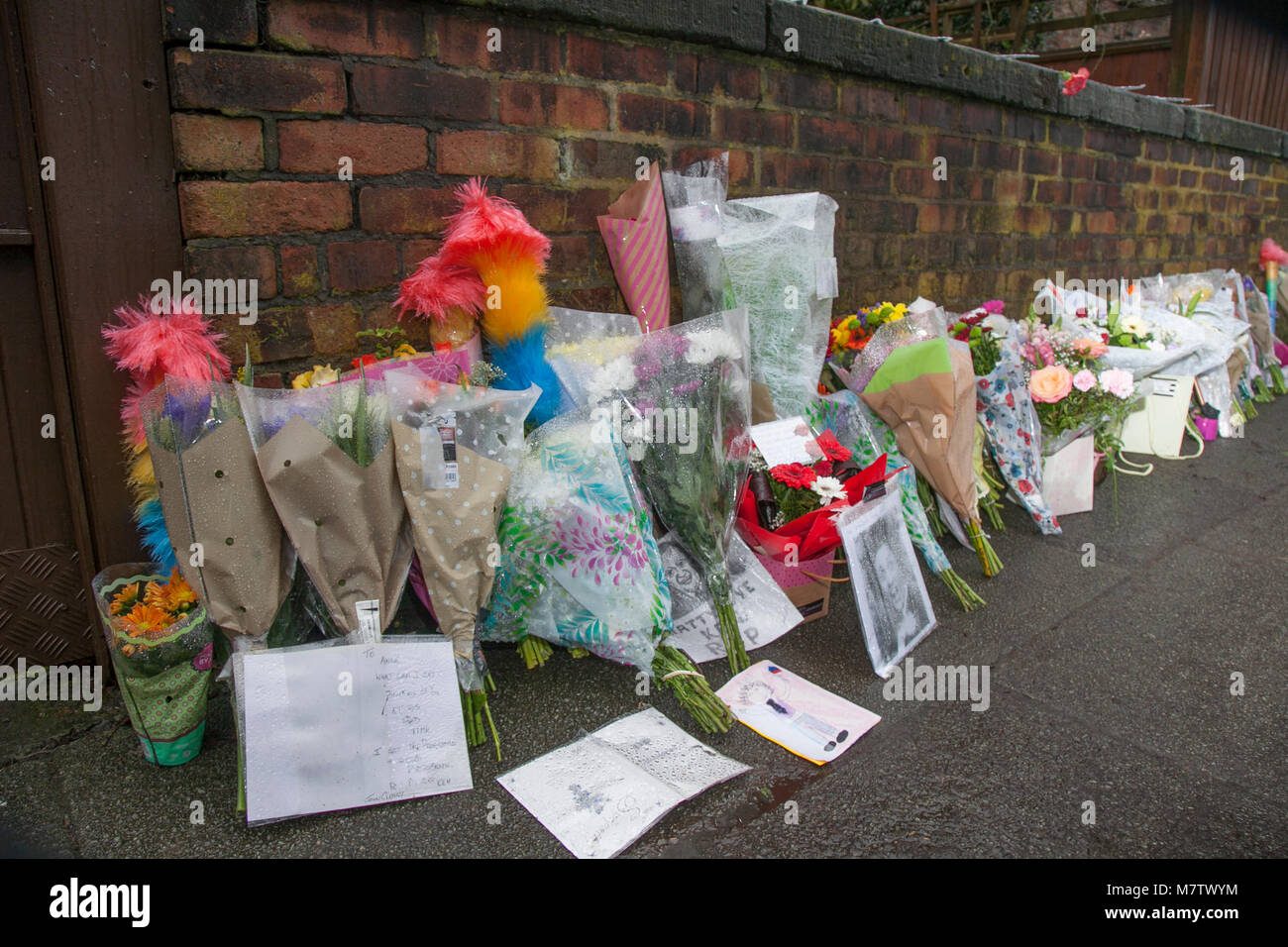Knotty Esche, Liverpool, Großbritannien. 13. März, 2018. Floral Tribute weiter außerhalb Ken Dodds Liverpool home als Bewohner der Stadt Ehre ein großer Komiker platziert zu werden. Blumen und Staubwedel, (ticking Sticks) haben außerhalb des Hauses in einer langen Linie, die entlang der Wand an der Grenze zum Grundstück platziert. Sir Ken Dodd starb im Alter von 90, mit Ehrungen aus aller Welt für die Viel-Komiker geliebt zu gießen. Kredit MediaWorldImages/AlamyLiveNews. Stockfoto