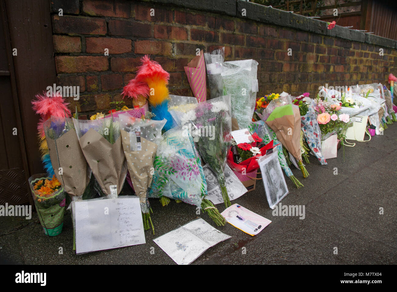 Knotty Esche, Liverpool, Großbritannien. 13. März, 2018. Floral Tribute weiter außerhalb Ken Dodds Liverpool home als Bewohner der Stadt Ehre ein großer Komiker platziert zu werden. Blumen und Staubwedel, (ticking Sticks) haben außerhalb des Hauses in einer langen Linie, die entlang der Wand an der Grenze zum Grundstück platziert. Sir Ken Dodd starb im Alter von 90, mit Ehrungen aus aller Welt für die Viel-Komiker geliebt zu gießen. Kredit MediaWorldImages/AlamyLiveNews. Stockfoto