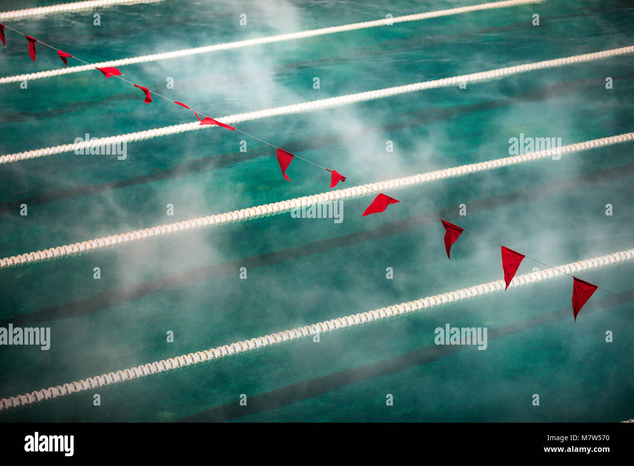 Korridor Gassen und Fahnen im Pool mit klarem blauen Wasser. Nebel über dem Wasser. Sport Wettbewerb. Stockfoto