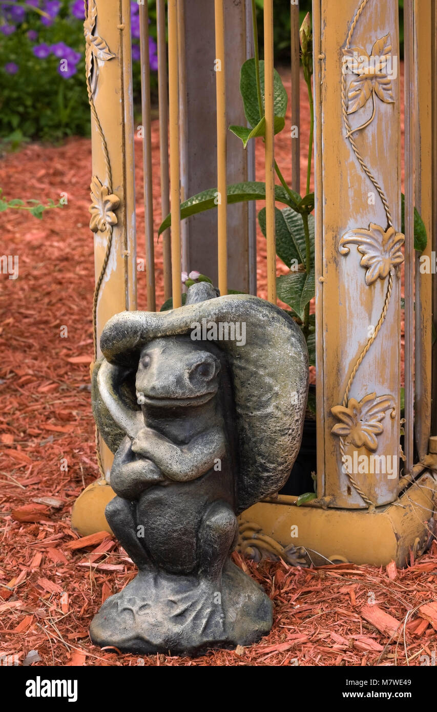 Nahaufnahme der Frosch Skulptur neben Säule auf goldenen schmiedeeisernen Tor aus Metall Laube im Garten im Sommer Stockfoto