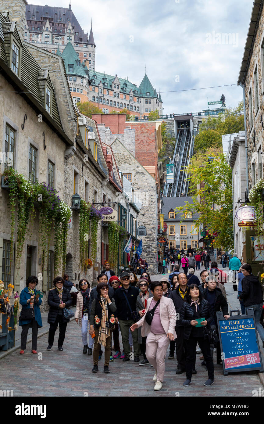 Quebec, Kanada. Asiatische Touristen in der unteren Stadt. Chateau Frontenac und der Seilbahn im Hintergrund. Stockfoto