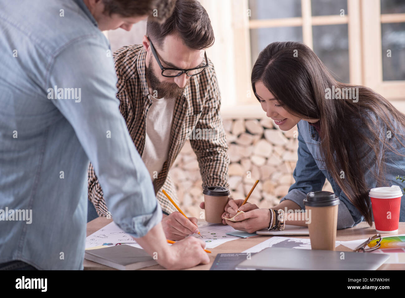 Freudige nette Studenten an einem Projekt arbeiten, Stockfoto