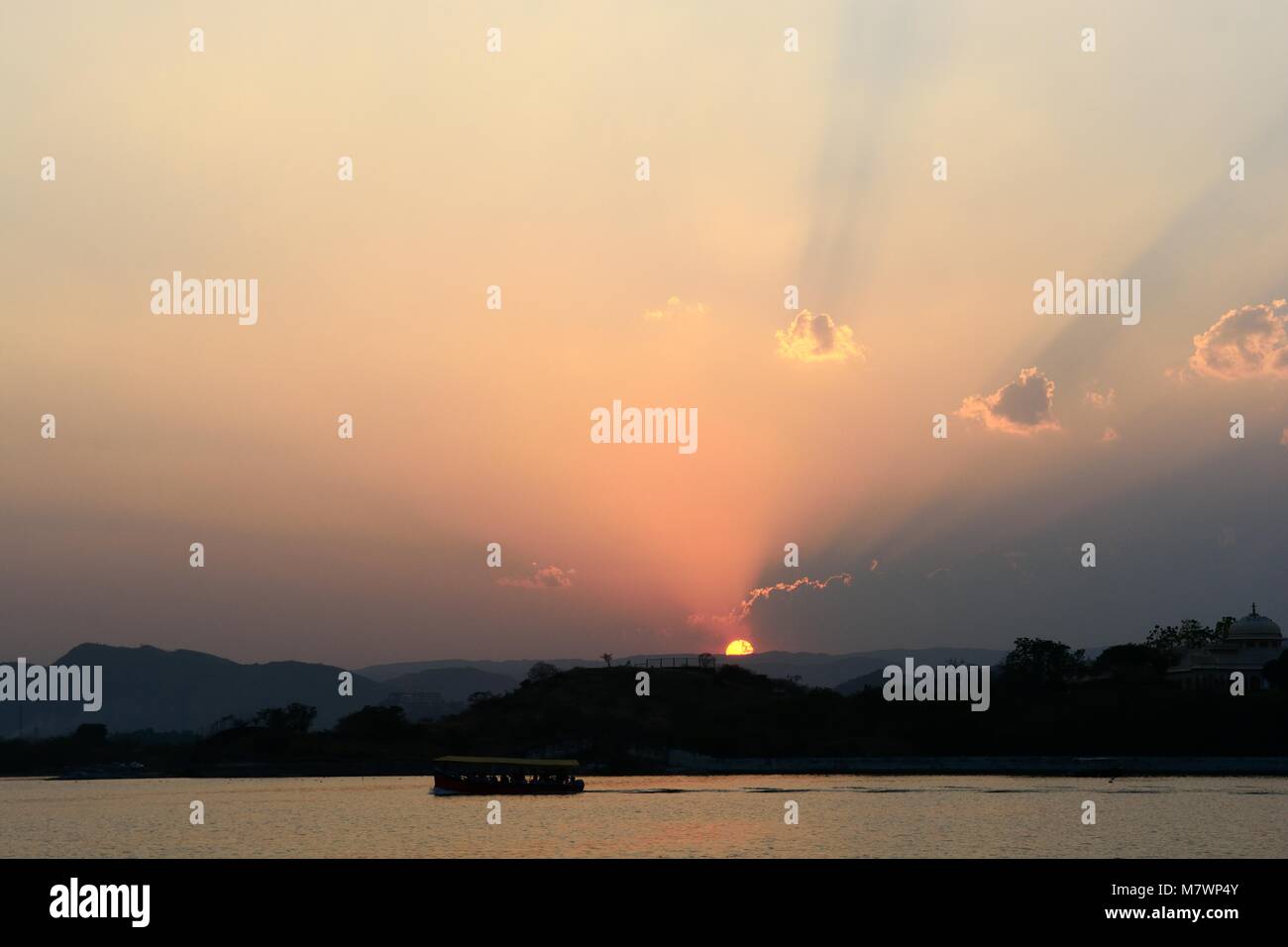 Sonnenuntergang und Sonnenstrahlen und Schiff über den Lake Pichola Rajashan Udaipur, Indien Stockfoto