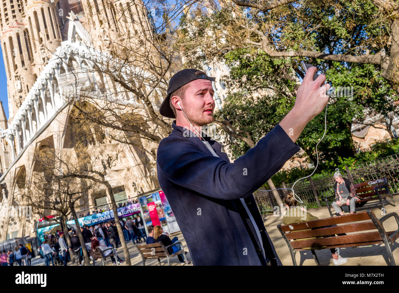 Ein junger Mann mit einem selfie außerhalb der Basilika Sagrada Familia in Barcelona. Stockfoto