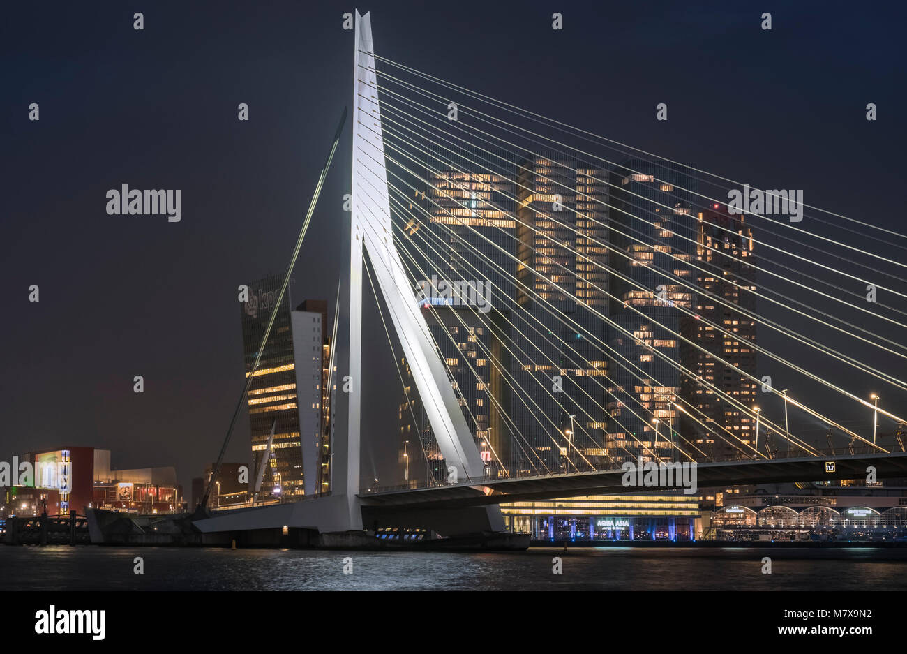 Erasmusbrug (Erasmus Brücke) und De Rotterdam Gebäude City Skyline bei Nacht, Rotterdam, Niederlande. Stockfoto