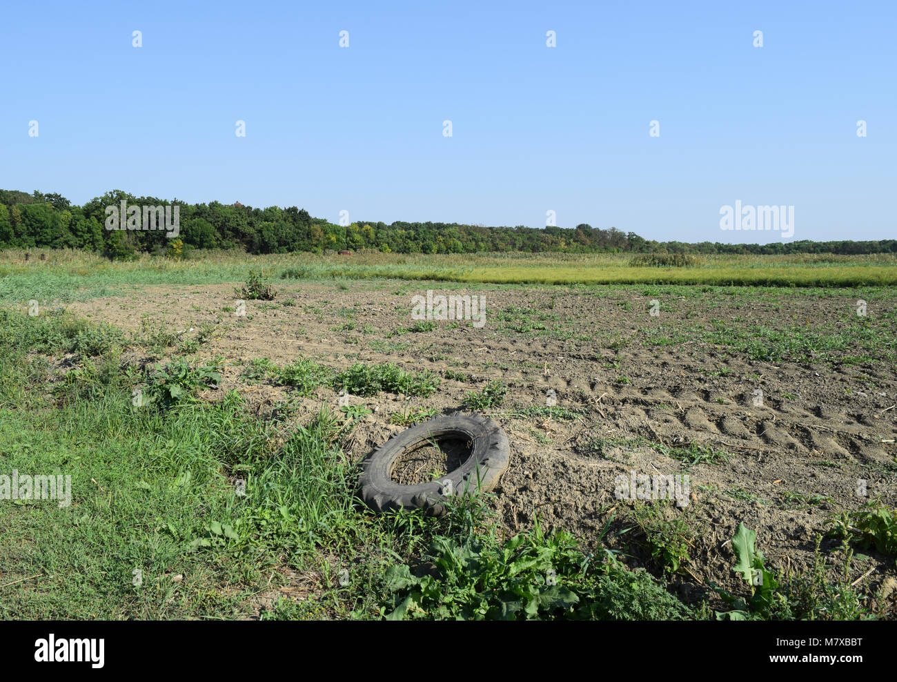 Das alte Rad protector liegt am Rande eines gepflügten Feldes. Stockfoto