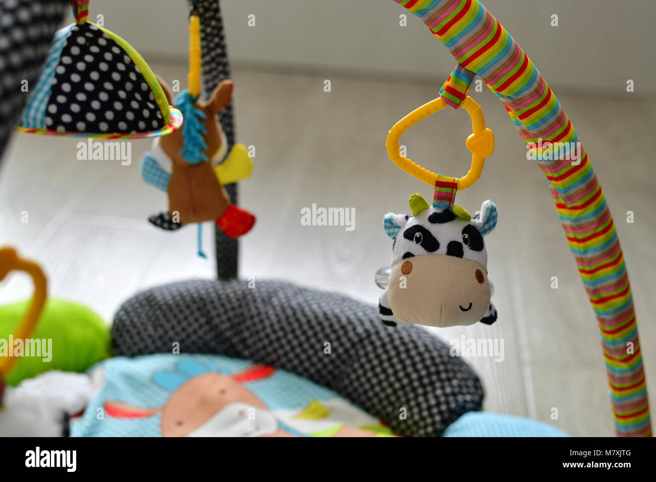 Spielzeug für Neugeborene hängen über Teppich Stockfoto