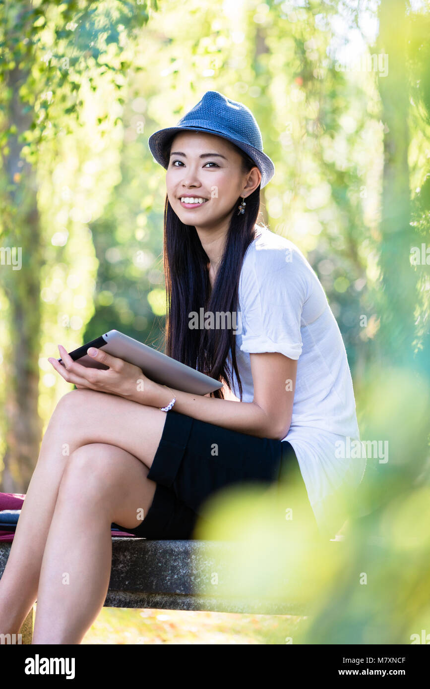 Asiatische Frau mit einem Tablet-PC im Freien Stockfoto