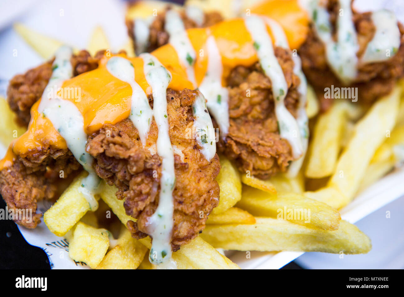 Fried Chicken und Chips mit Käse. Stockfoto