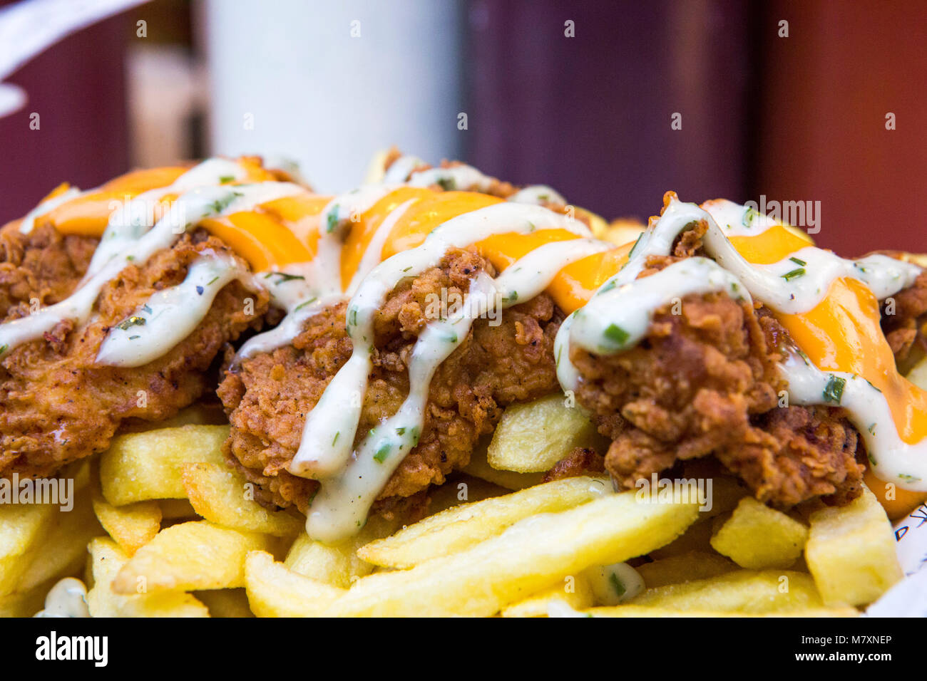 Fried Chicken und Chips mit Käse. Stockfoto