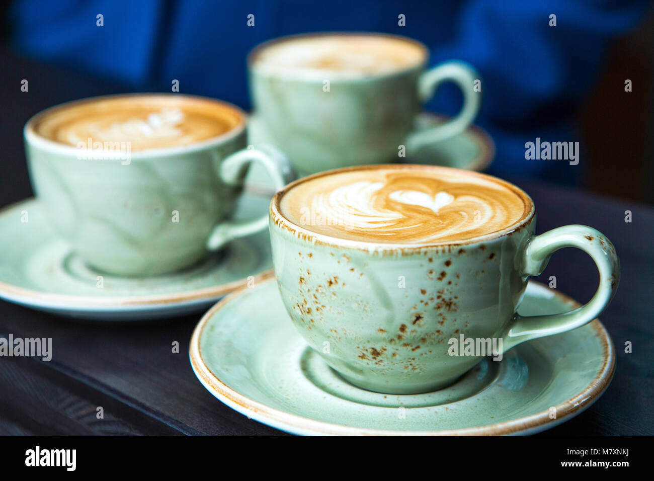 Cappuccino in grünem Kaffee Tasse und Untertasse mit Herz. Stockfoto