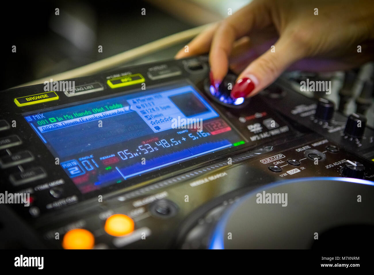 Weibliche DJ mit roten Fingernägeln auf Cdj's und Mixer. Stockfoto