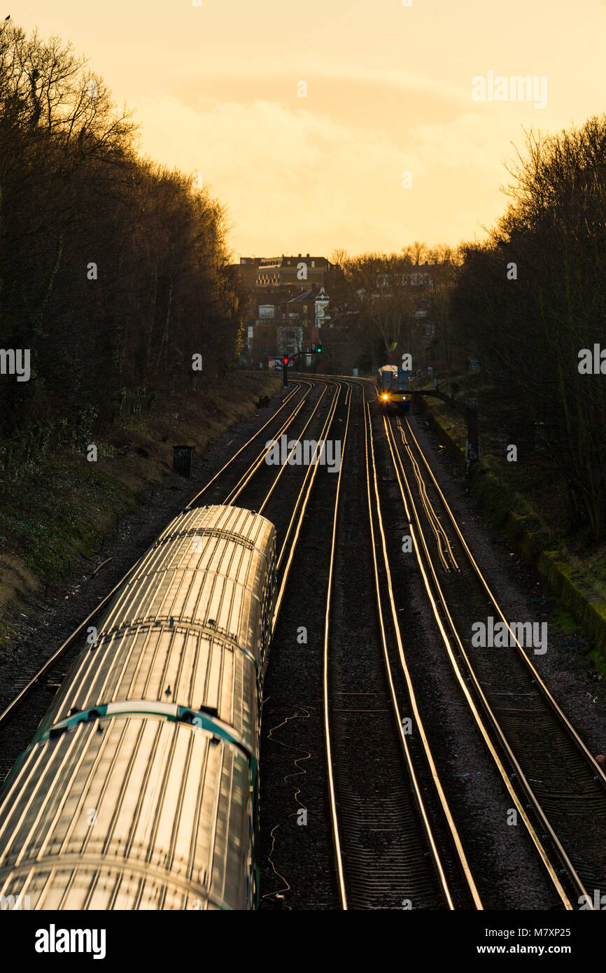 Eisenbahnlinien mit Zügen im südlichen London bei Sonnenuntergang Stockfoto