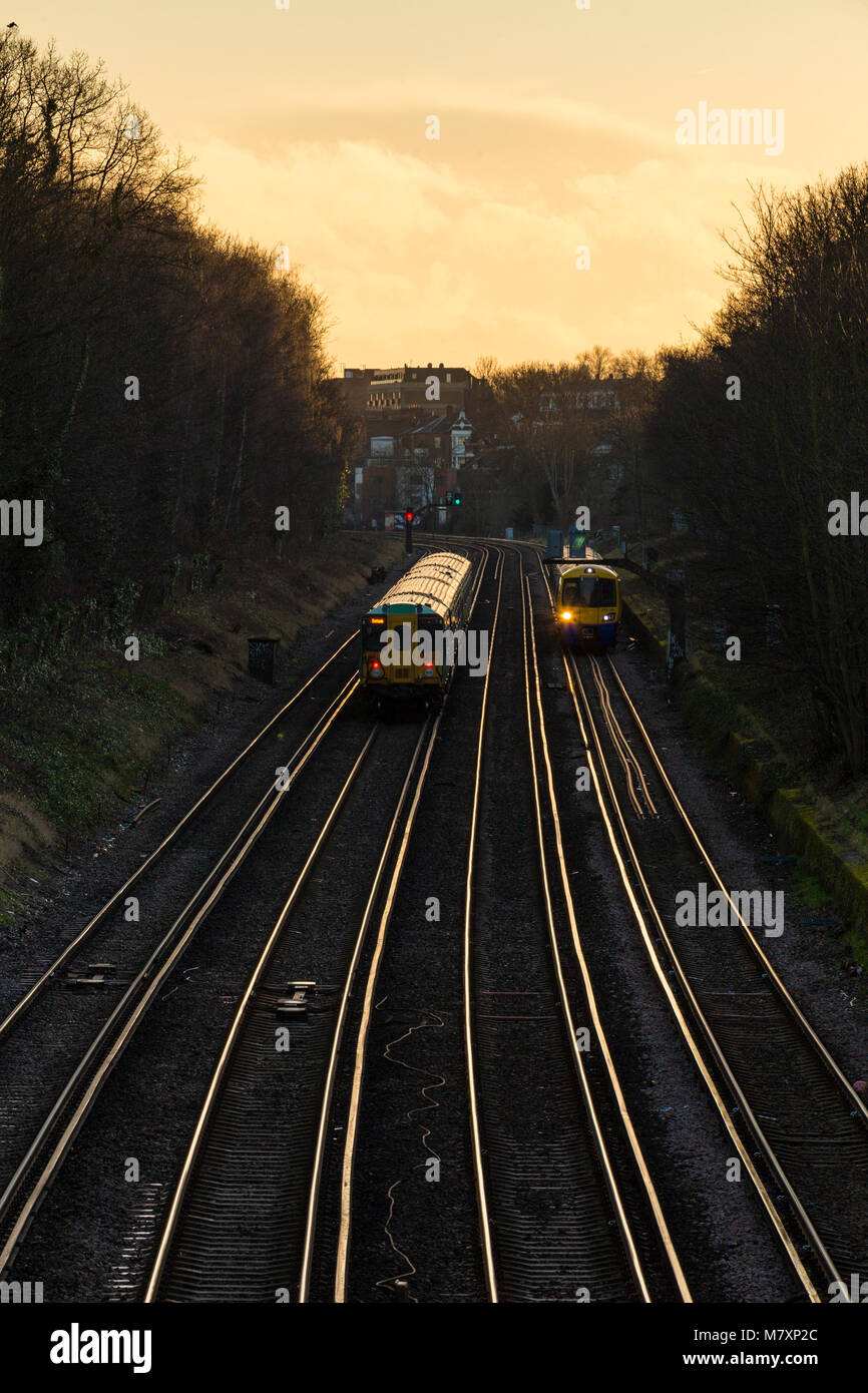 Eisenbahnlinien mit Zügen im südlichen London bei Sonnenuntergang Stockfoto