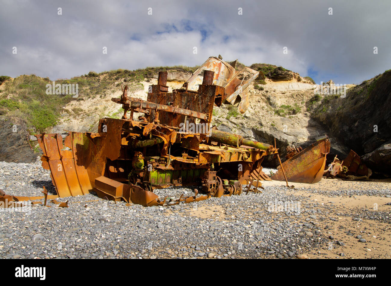 Von Heck bis Bug, ein fast zerstört Drücker Boot ruiniert, verrostet und die Hälfte am Strand Sand begraben. Vila Nova de Milfontes, Portugal. Stockfoto