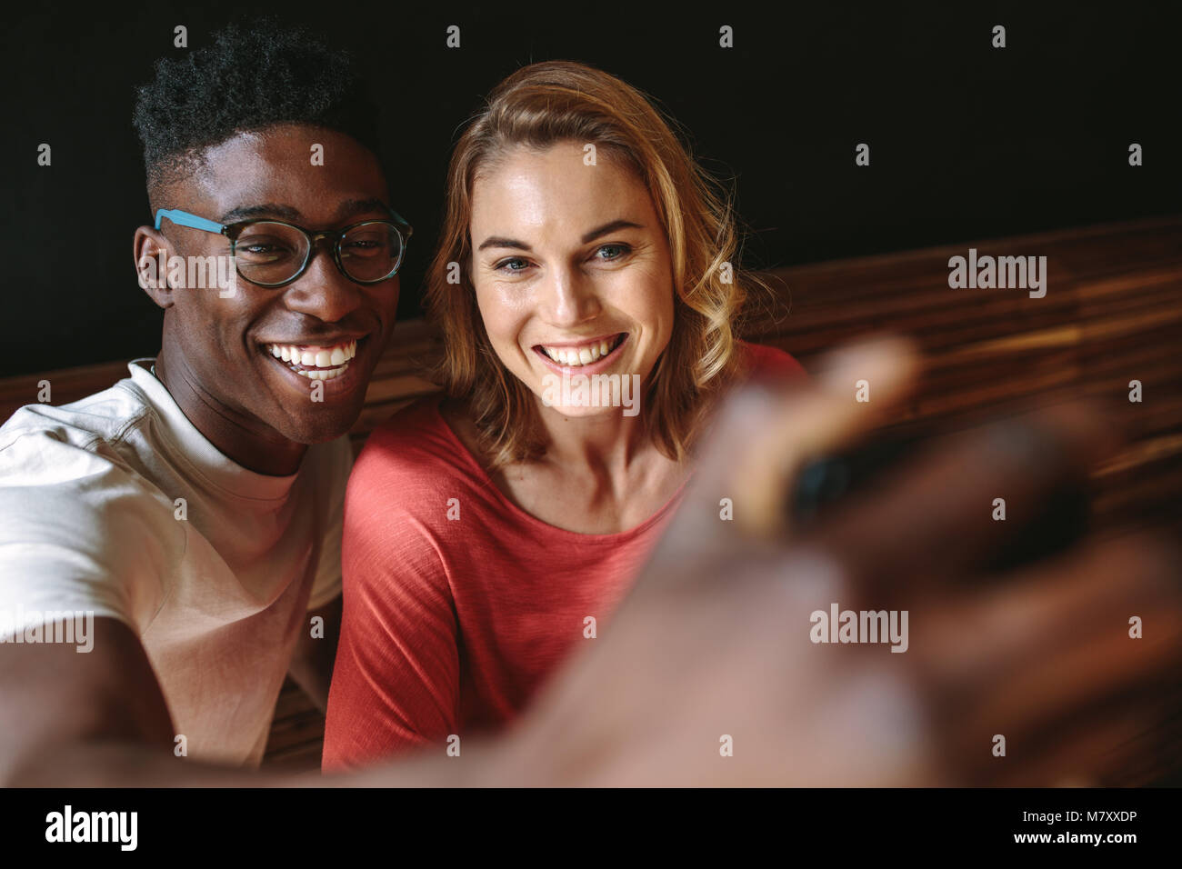Mann und Frau teilen glückliche Momente im Coffeeshop. Lächelndes Paar ein selfie mit Handy. Stockfoto
