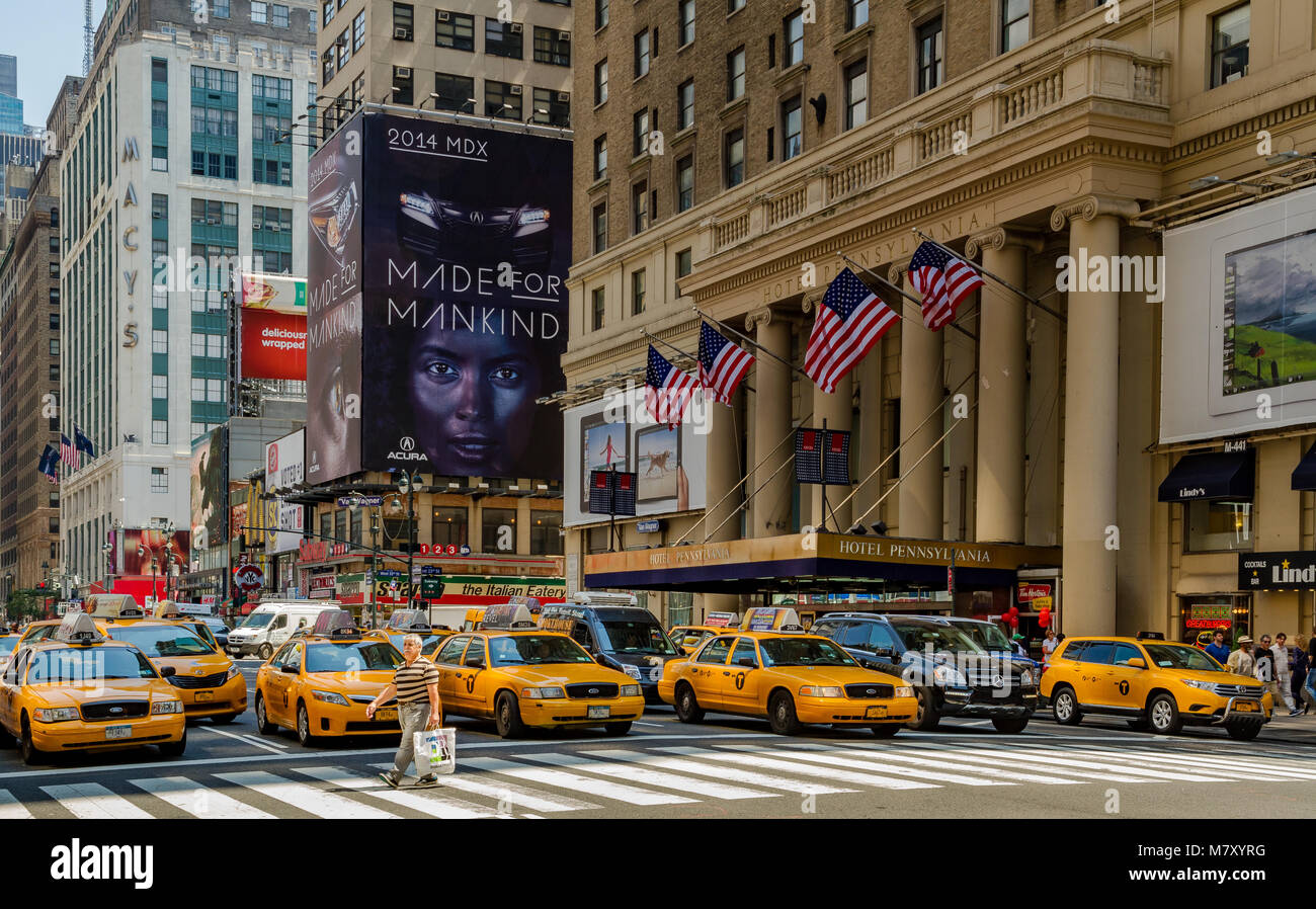 Mann auf einem fußgängerüberweg vor einer Position mehrere gelbe New York Taxis außerhalb des Pennsylvania Hotel an der Seventh Avenue, Manhattan, NY Stockfoto