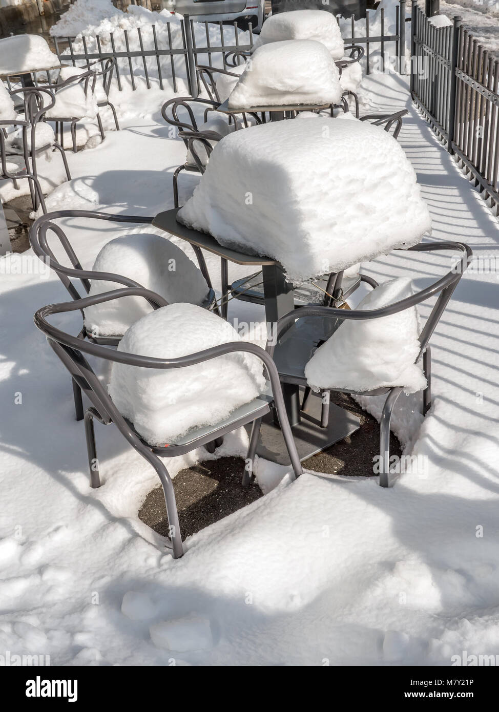 Leere Stühle und Tische mit schweren Schneedecke außerhalb Restaurant abgedeckt Stockfoto