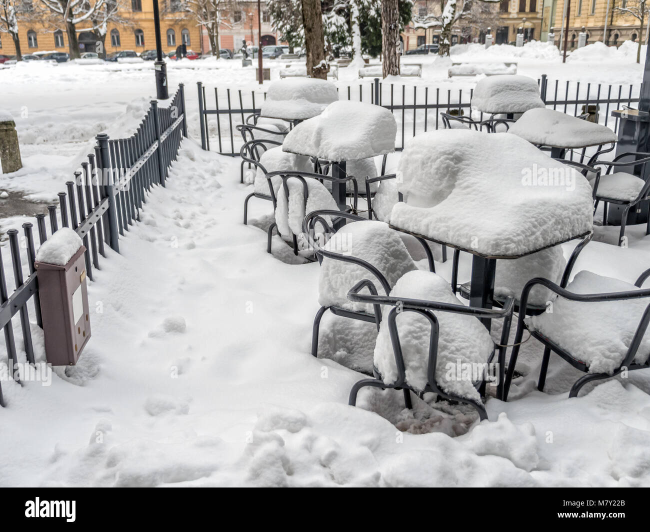 Leere Stühle und Tische mit schweren Schneedecke außerhalb Restaurant abgedeckt Stockfoto