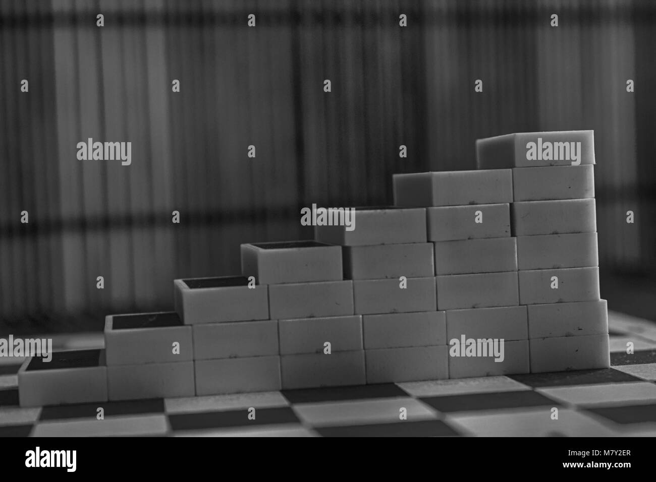 Monochrome Pyramide der Dominosteine auf der Bambus braun Holztisch Hintergrund Stockfoto