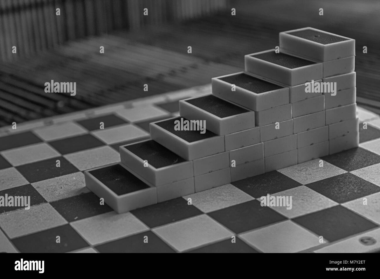 Monochrome Pyramide der Dominosteine auf der Bambus braun Holztisch Hintergrund Stockfoto