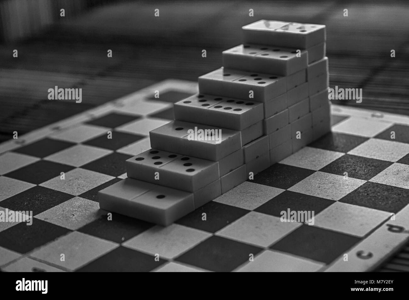 Monochrome Pyramide der Dominosteine auf der Bambus braun Holztisch Hintergrund Stockfoto