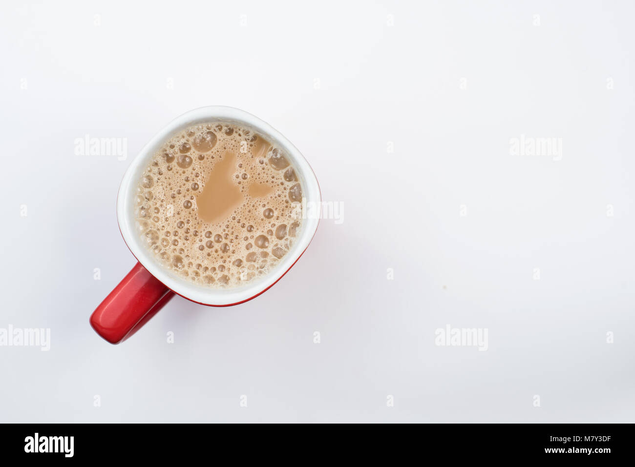 Blick von oben auf die schaumigen Milch Kaffee oder Milch Kaffee in einer Tasse Rot auf weißem Hintergrund Stockfoto