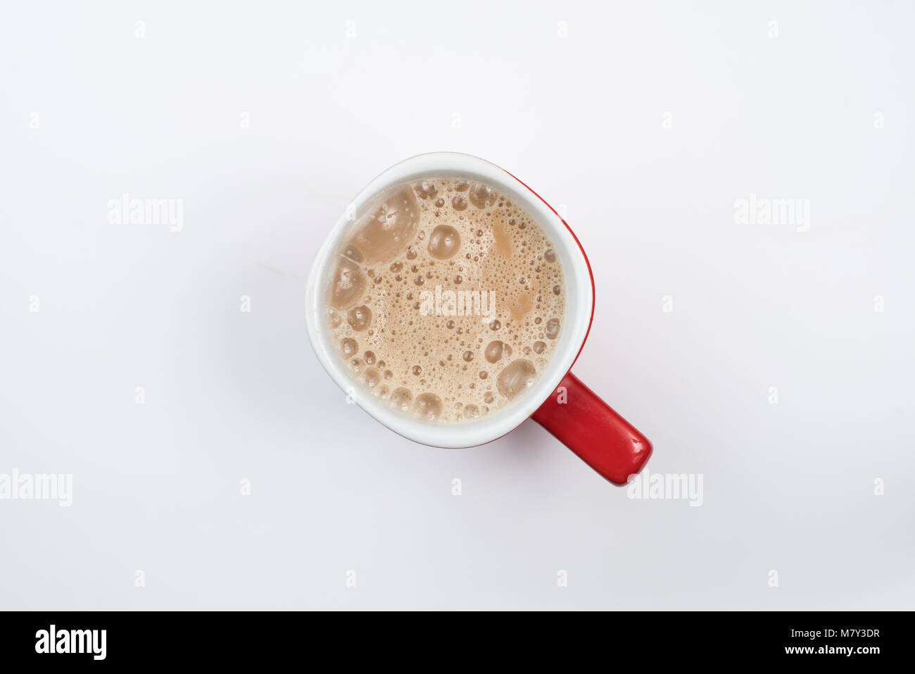 Blick von oben auf die schaumigen Milch Kaffee oder Milch Kaffee in einer Tasse Rot auf weißem Hintergrund Stockfoto