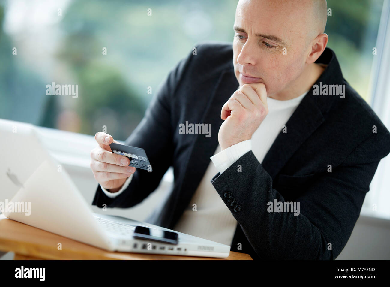 Mann mit Laptop holding Kreditkarte Stockfoto