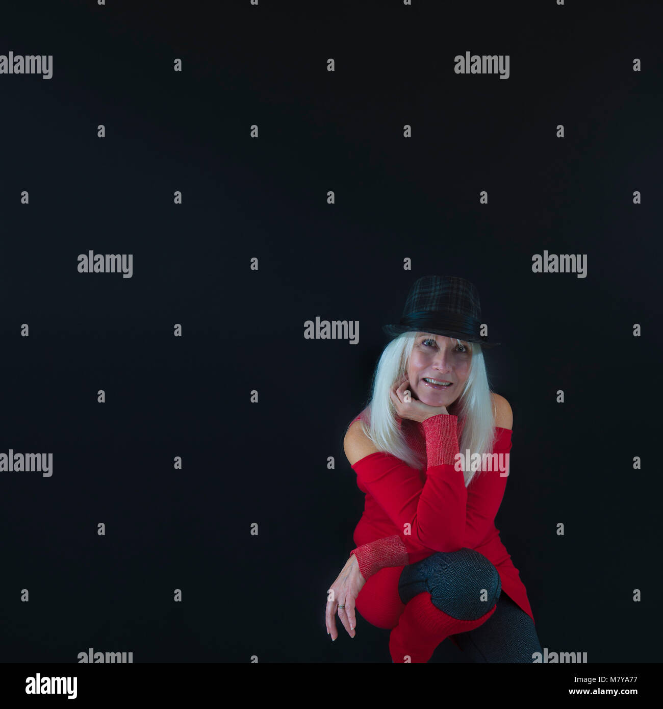 Selbstportrait des Fotografen mit Copyspace, das Tragen von grauen und schwarzen Hut mit weißem Haar, rot pullover und Beinlinge und grauen Leggings. Stockfoto