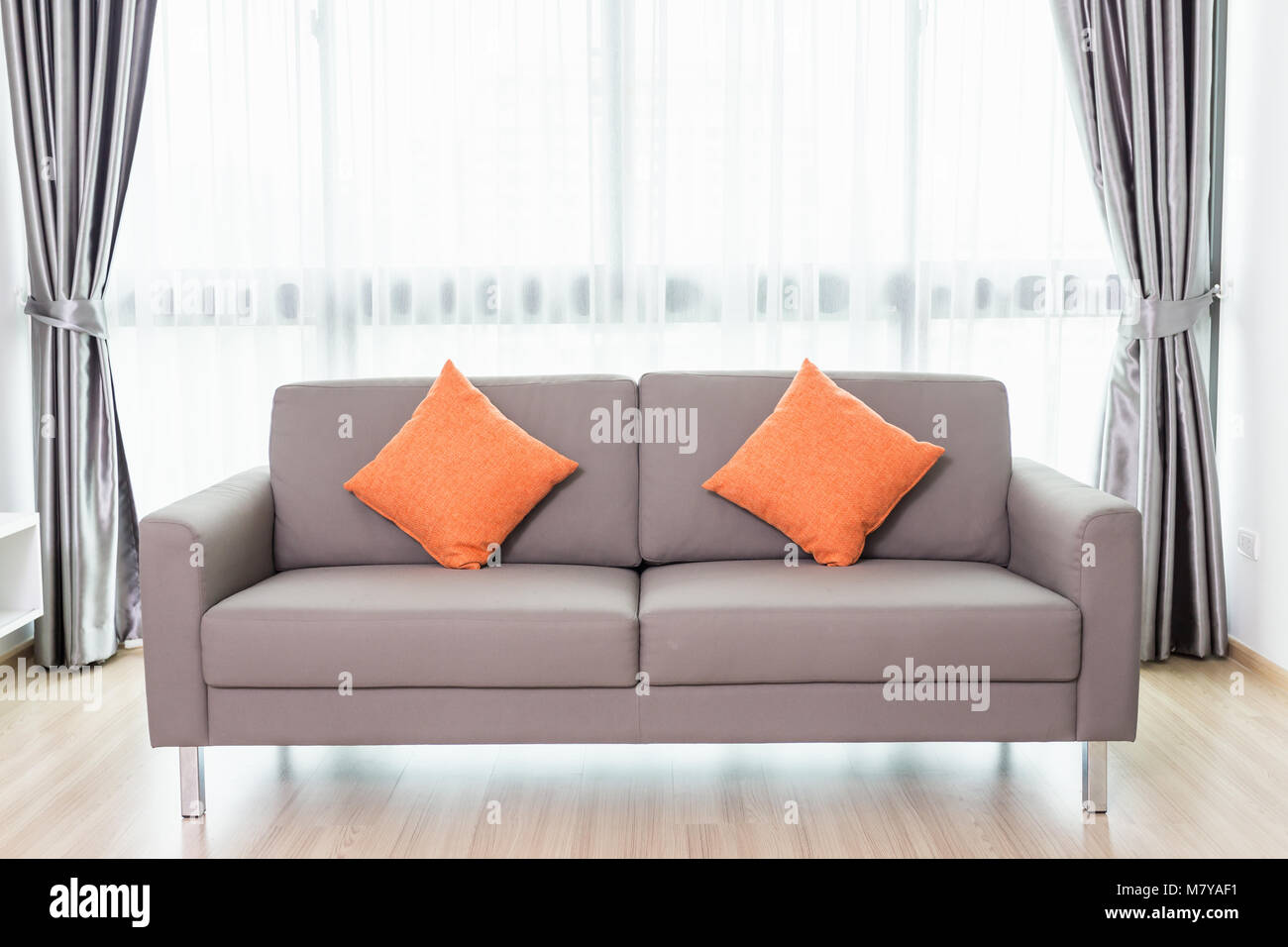 Graue Sofa im Wohnzimmer neben dem Fenster. Home Inneneinrichtung Stockfoto