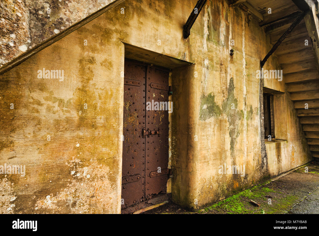 Außenwand von einem alten, verlassenen Bunker mit Stahltür. Stockfoto