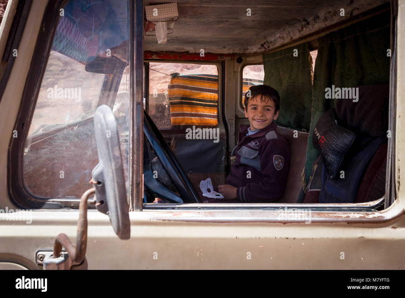 Jungen Beduinen Junge in einer alten Toyota Allradantrieb in den Wadi Rum in Jordanien sitzt. Stockfoto
