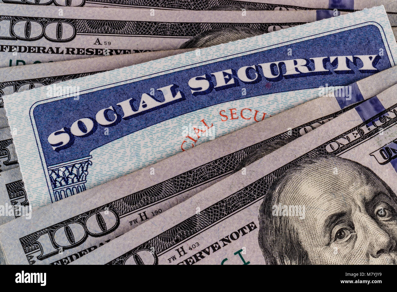 Social Security Card und ein Bett, das Geld für die hohen Kosten des Lebens auf einem festen Einkommen II. Stockfoto