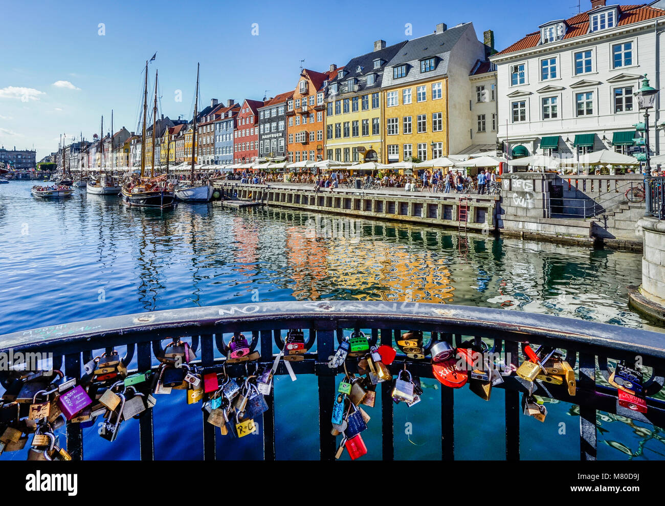Dänemark, Seeland, Kopenhagen, liebe Sperren auf Nyhavn Brücke mit Blick auf den Kanal Hafen Wasserfront von Nyhavn, mit bunten Stadthäuser, Res Stockfoto