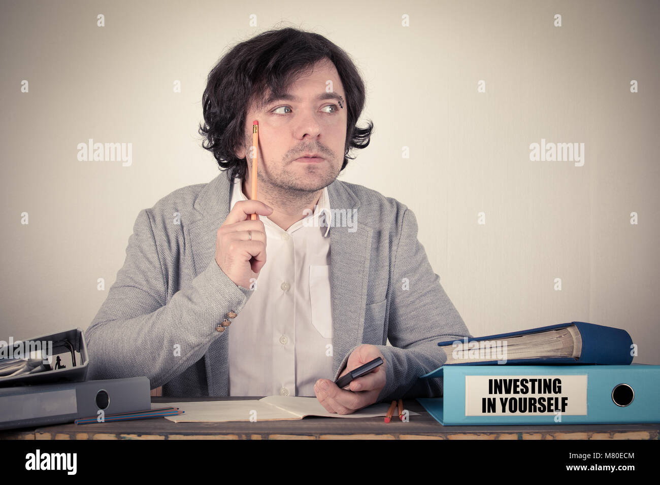 Investitionen in die Sie sich auf den BINDER, besorgt bussinesman Denken vom Schreibtisch Stockfoto