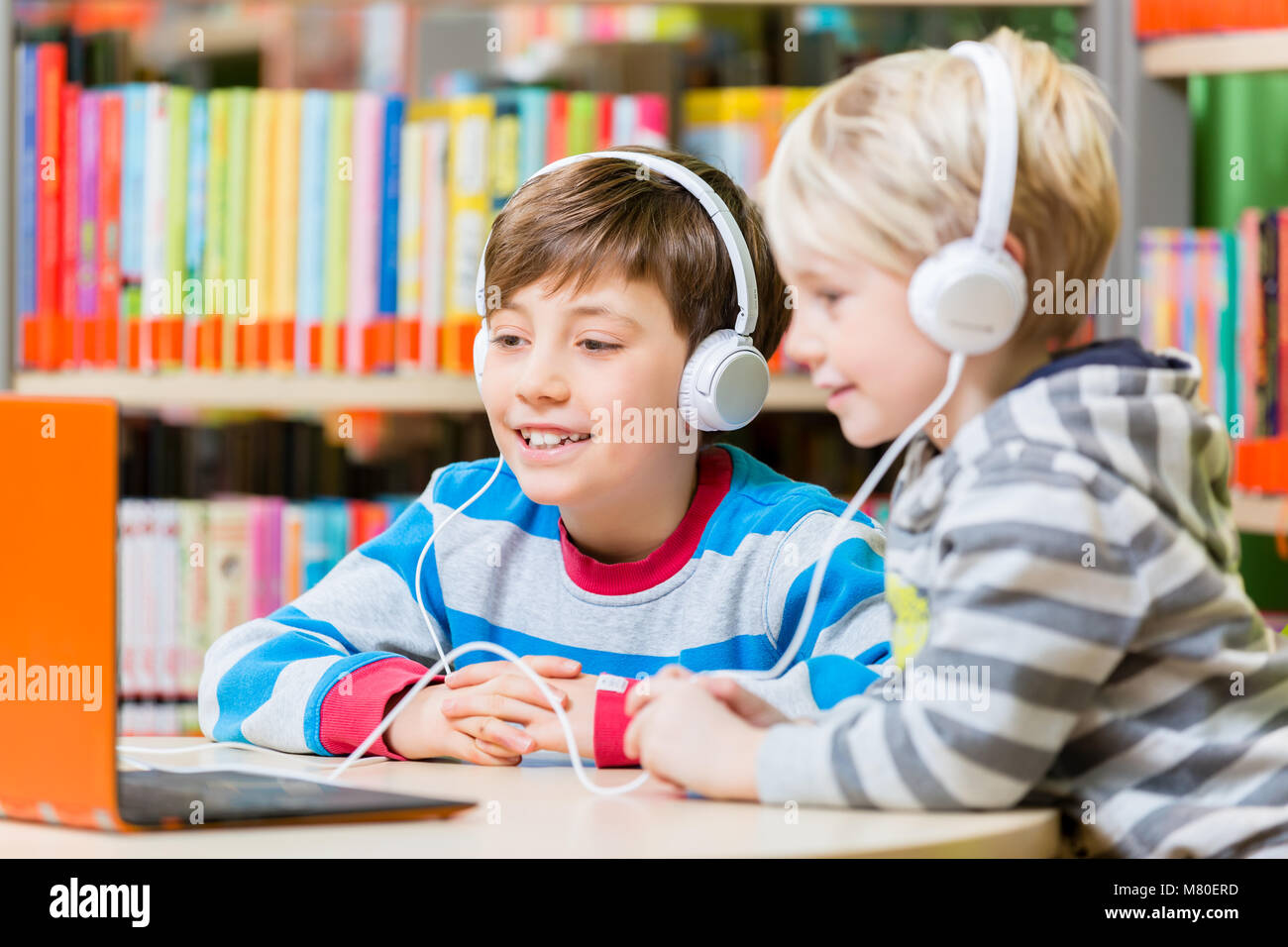 Kinder in einer Bibliothek zu den Audiobüchern hören Stockfoto