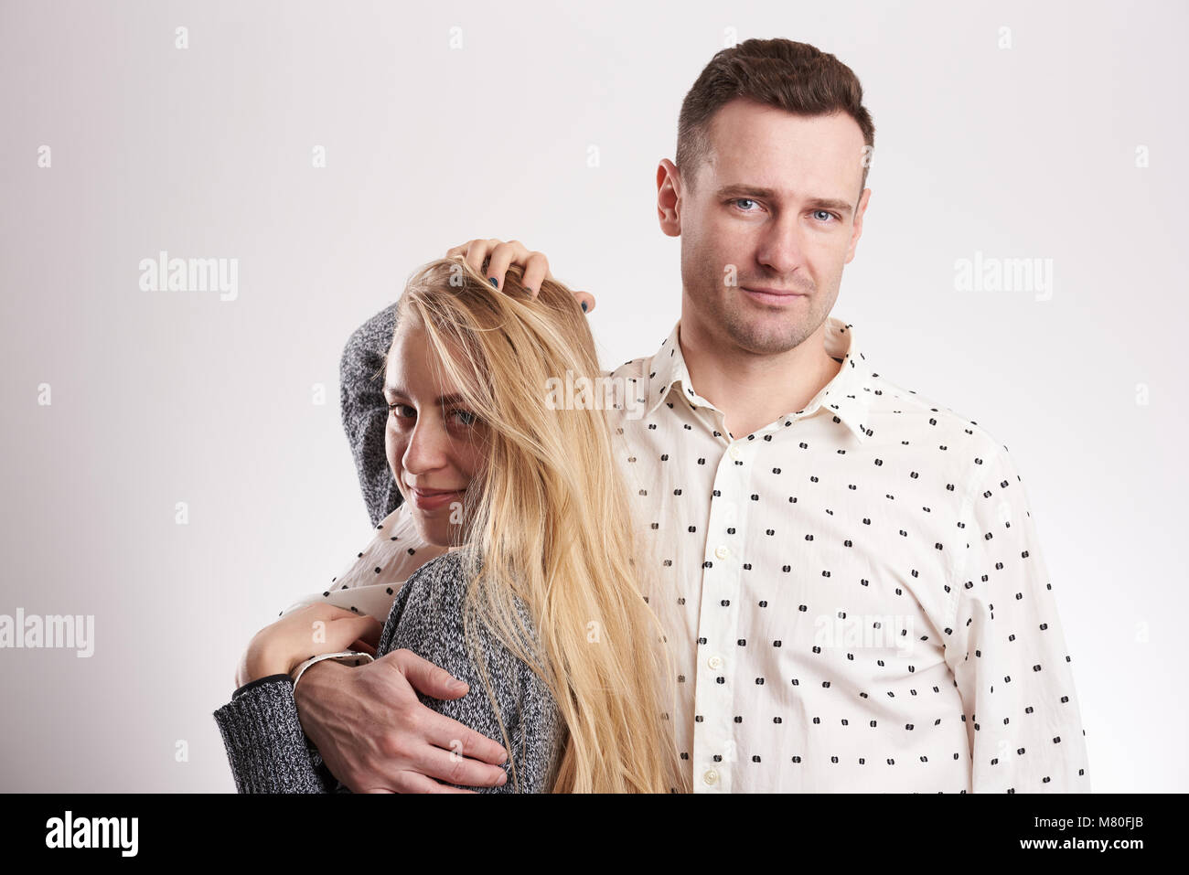 Junge moderne Paar in Studio isoliert. Brünett Mann und die blonde Frau Stockfoto