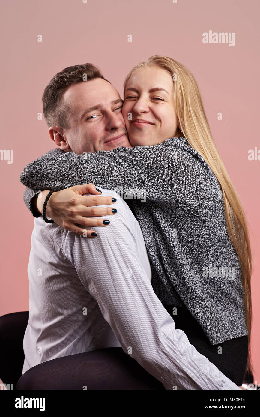 Kaukasische Paar in Liebe umarmen auf rosa Hintergrund isoliert Stockfoto