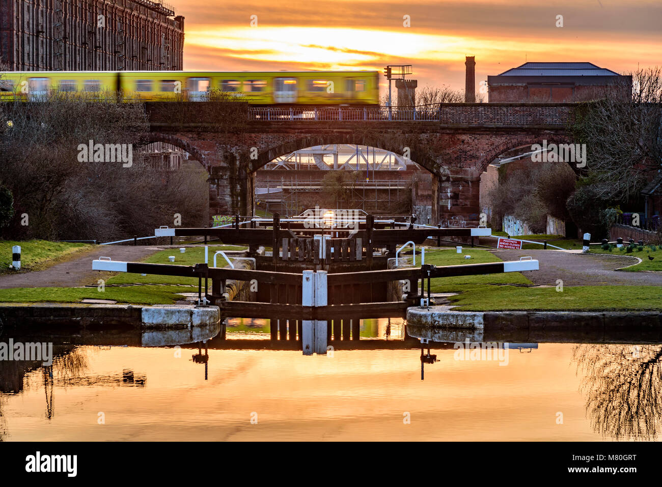 Merseyrail elektrische Zug Überfahren der Leeds Liverpool Canal Locks in Stanley Dock. Abendlicht. Sonnenuntergang Stockfoto