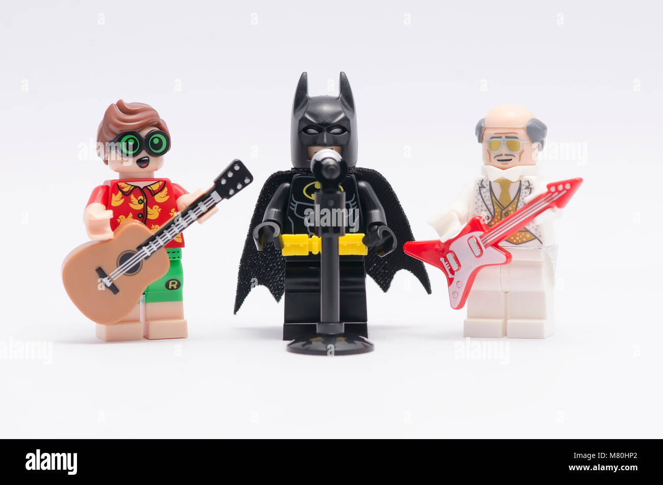 "Lego Batman" singen mit Alfred und Robin Gitarre zu spielen. auf weißem Hintergrund. Stockfoto