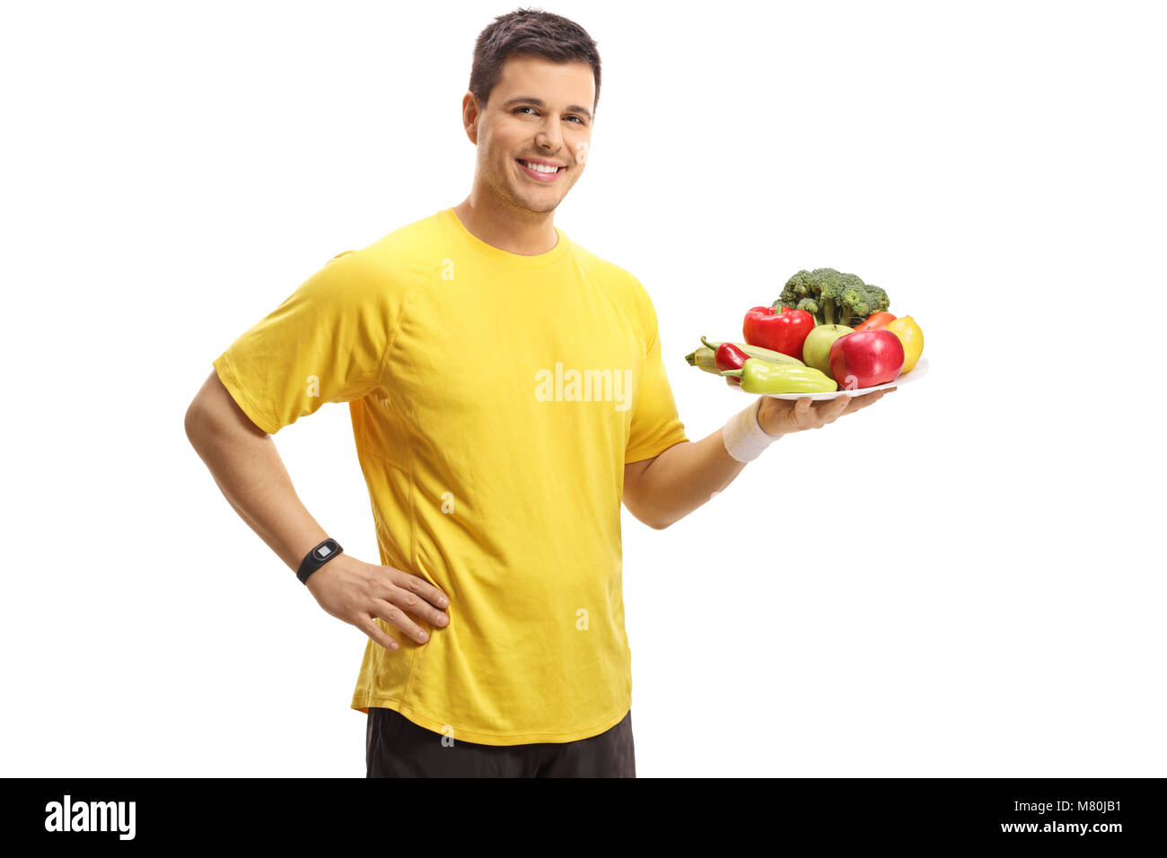 Junge Mann hält einen Teller mit Obst und Gemüse auf weißem Hintergrund Stockfoto