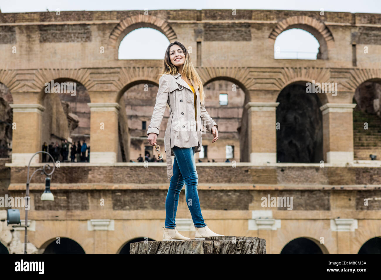 Junge hübsche touristische Frau lächelnd und am Colosseum Monument in Rom Italien posing Stockfoto