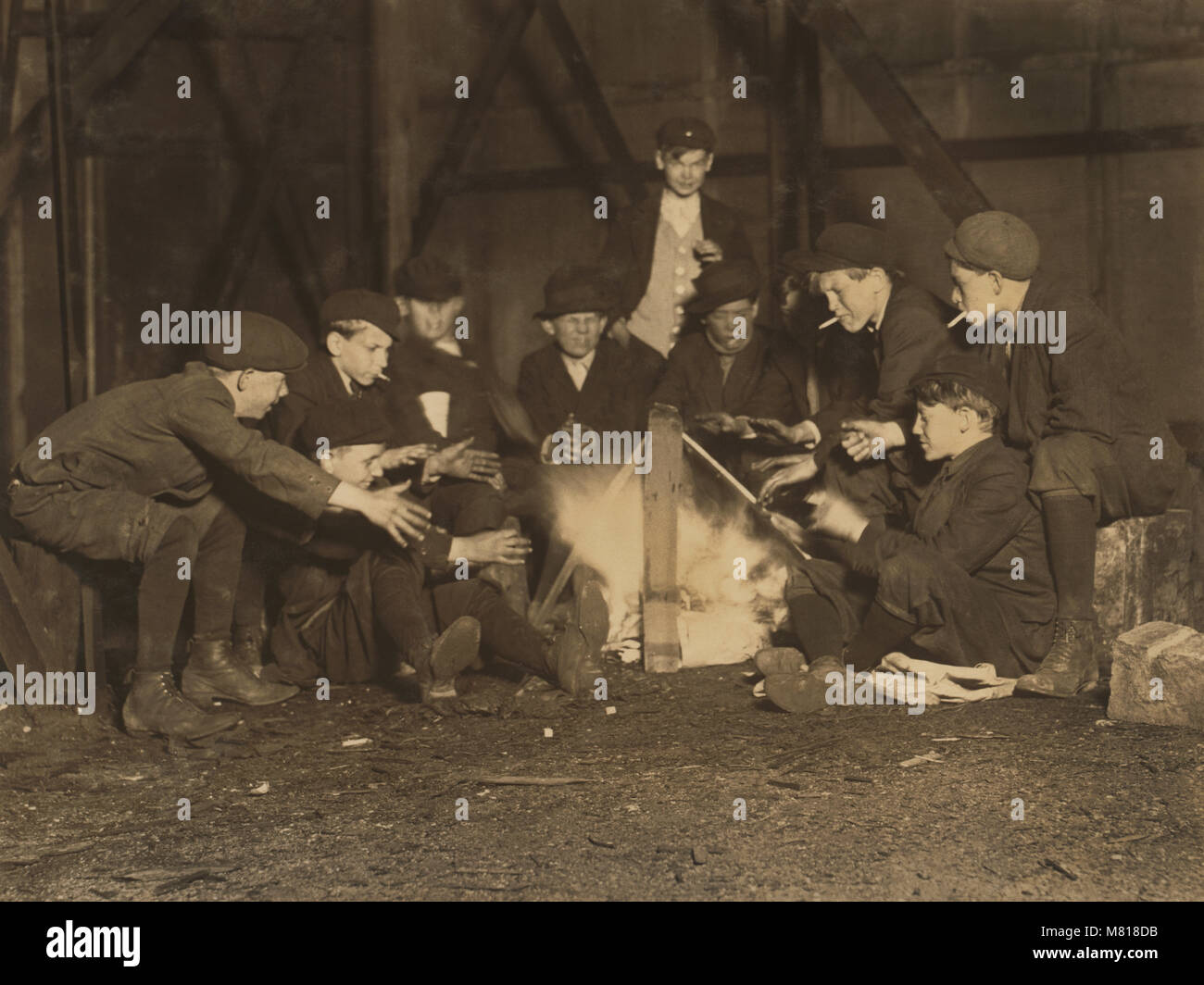 Bande von Newsboys bleiben Warm über dem Lagerfeuer in der Ecke viel in der Nacht, Jefferson Street in der Nähe von Olive, St. Louis, Missouri, USA, Lewis Hine für nationale Kinderarbeit Ausschuss, Mai 1910 Stockfoto