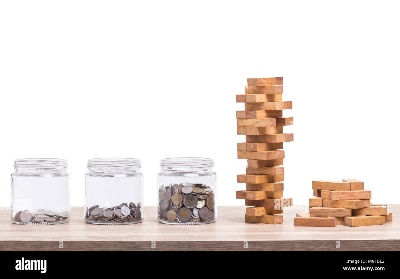 Stapel der Bausteine Holz Spiel und jar von Münze Sparschwein auf hölzernen Tisch. Studio geschossen und auf weißem Hintergrund Stockfoto