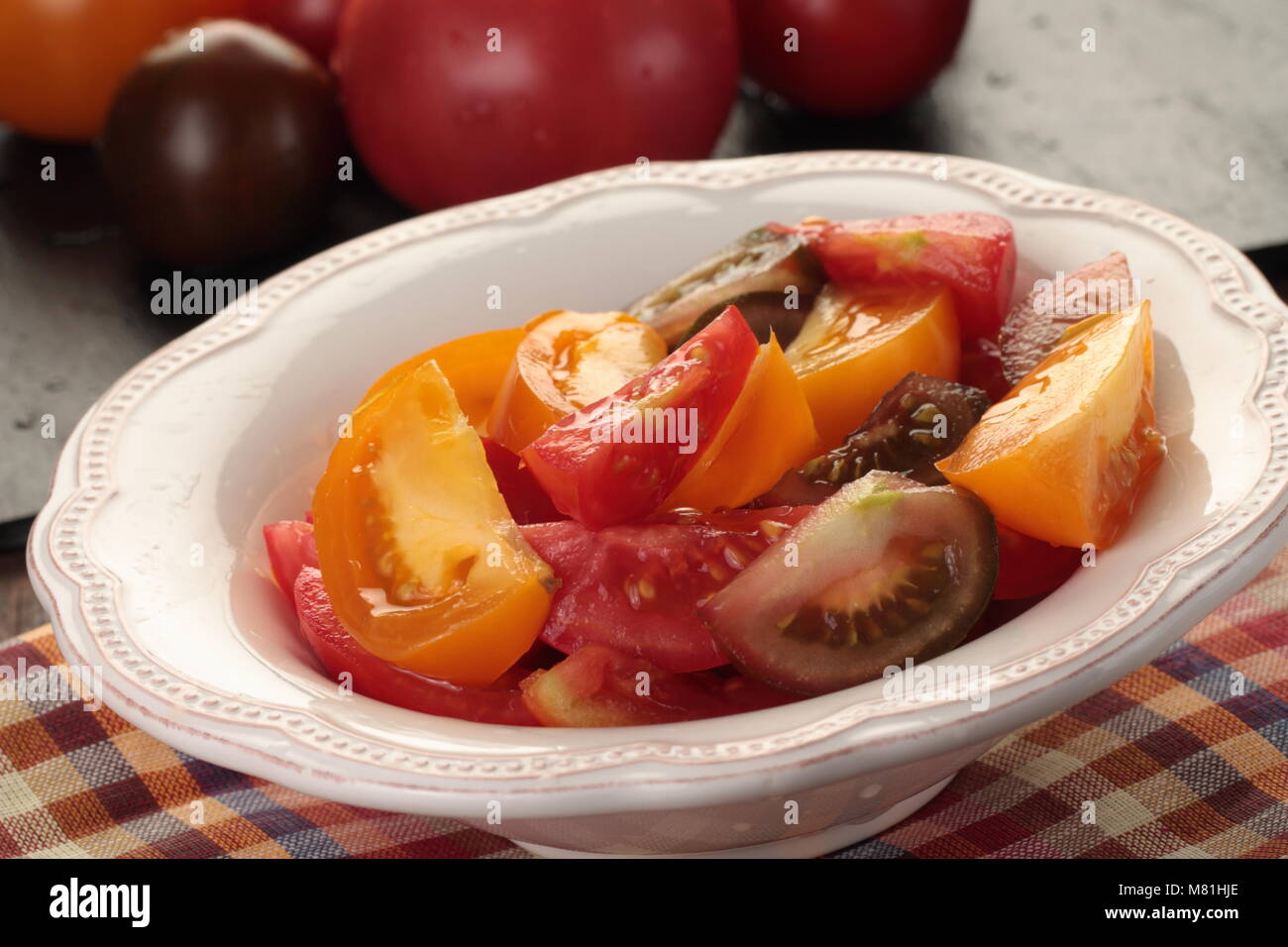 In Scheiben geschnittene Tomaten in einer Schüssel auf einem rustikalen Tisch Stockfoto