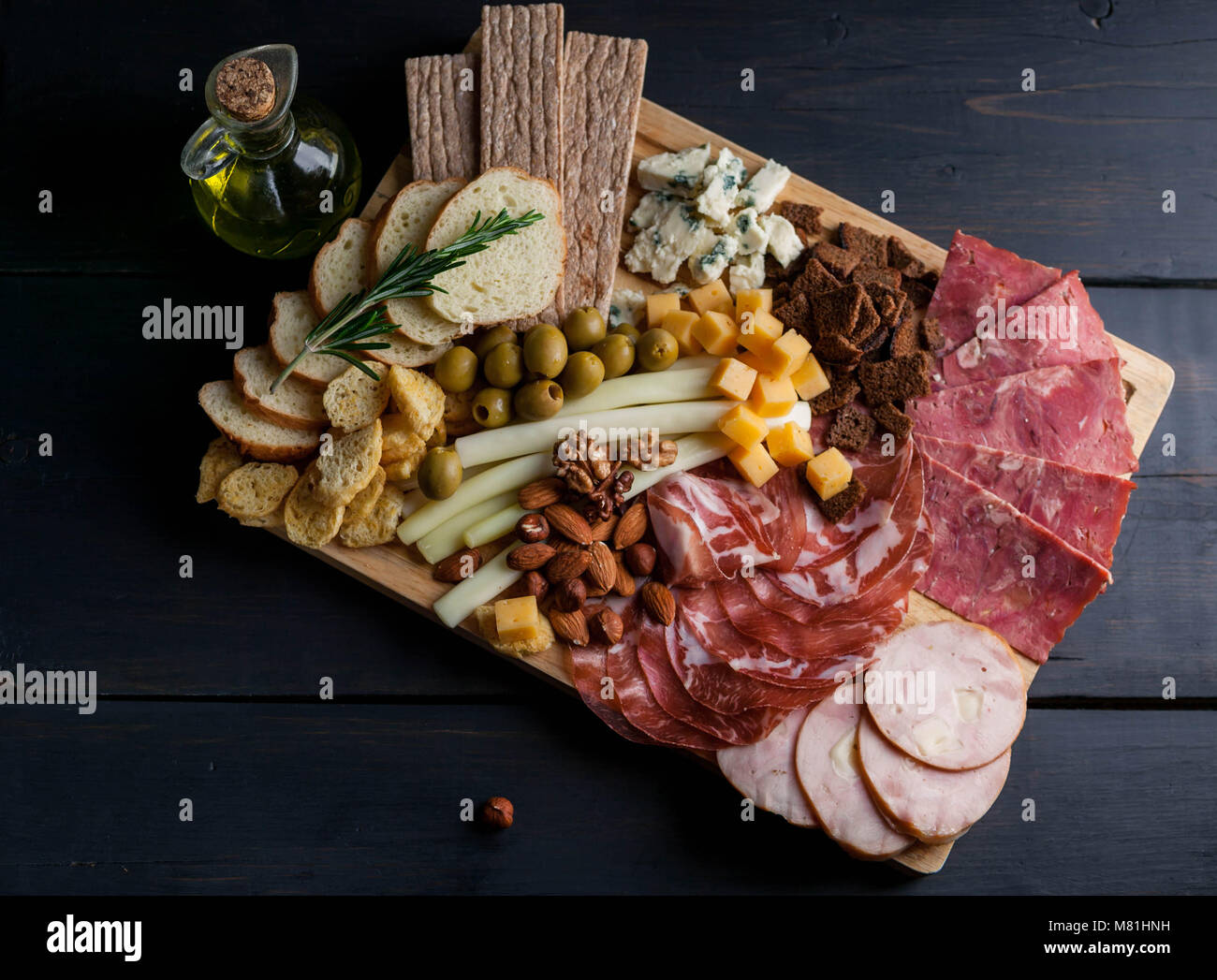 Aus Fleisch und Käse auf einem Schneidebrett sortiert. Geräucherte Wurst, Fleisch aus der Türkei mit Käse, Schinken, Oliven, Nüsse und verschiedene sorten Käse. Mediterrane traditionelle Snacks. Ansicht von oben Stockfoto