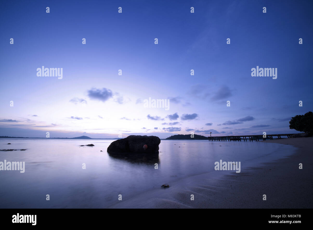 Lange Belichtung Foto der Strand von Cempedak Private Insel mit Steg, Bintan Regency, Riau Inseln, Indonesien, während der Blauen Stunde Stockfoto