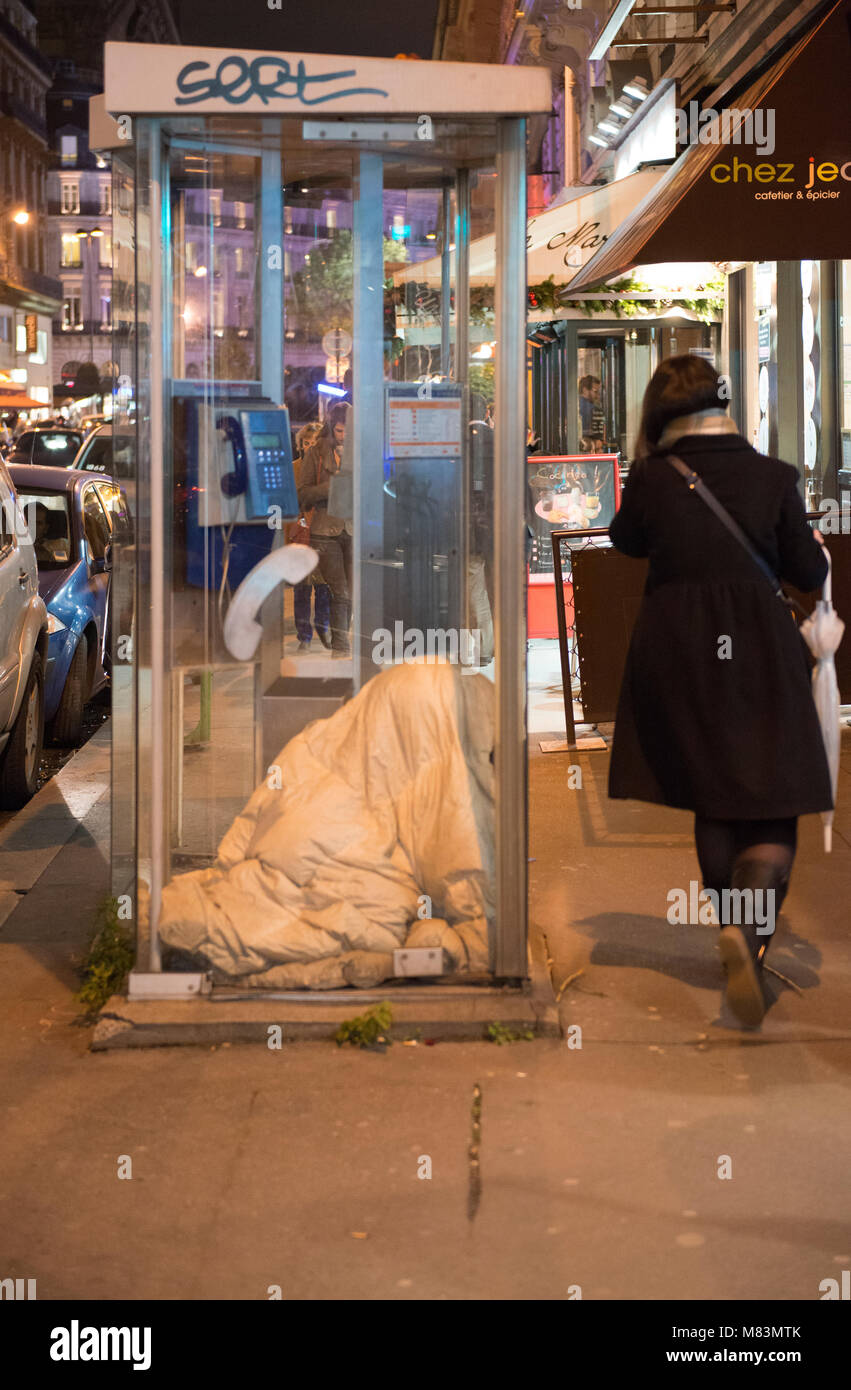 Obdachlosen schlafen in der Telefonzelle in der Straße der Stadt Paris, Frankreich Stockfoto