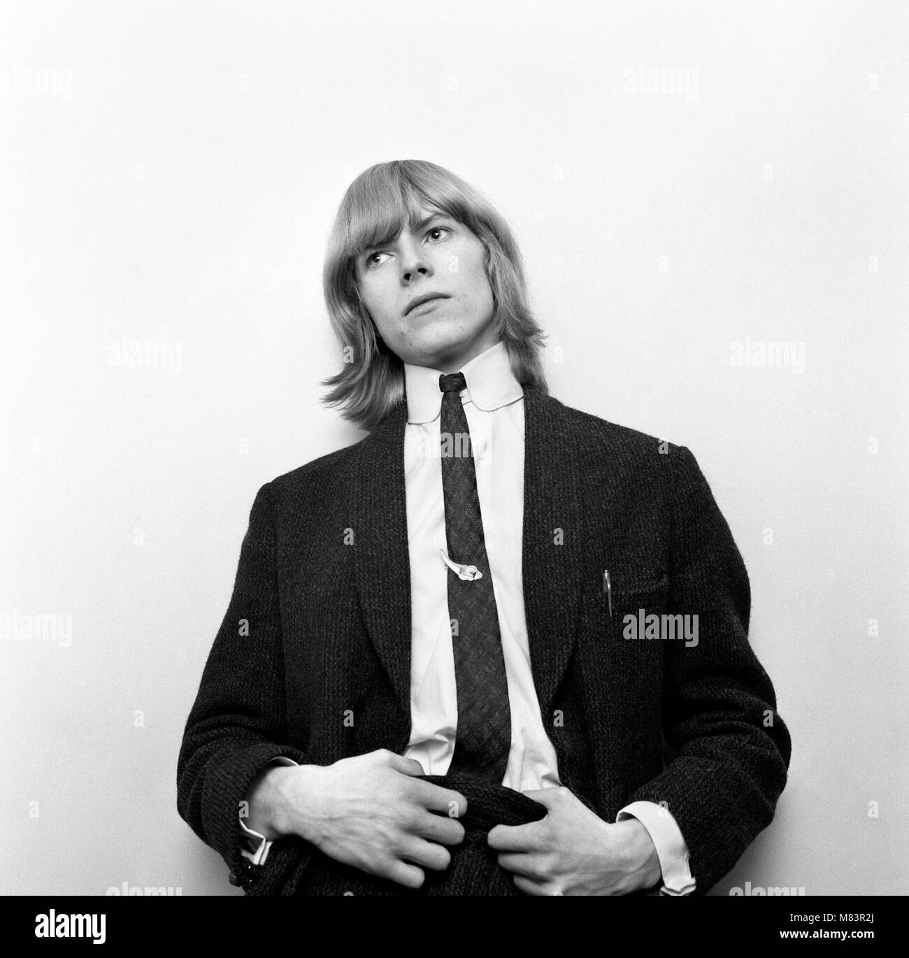 British pop Sänger David Bowie dargestellt, als er als Davie Jones bekannt war, außerhalb der BBC Television Centre warten zu Barry Langford zu sprechen, Produzent der Show 'Gadzooks sein Alles geschieht!". Davie und seine Gruppe wurden aufgrund der Länge der Haare verboten, aber der Produzent schließlich erlaubt Ihnen auf den Montag abend auf der Zustand zu erscheinen Sie erhalten Ihr Haar durch die BBC-TV-Make-up-Abteilung durchgeführt. 5. März 1965 Stockfoto